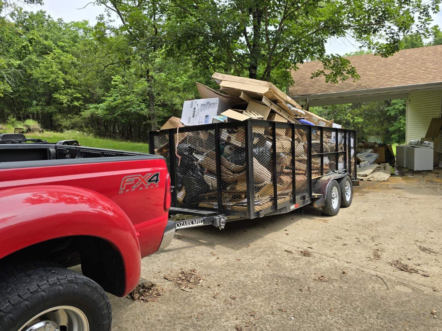 A 417 Hauling truck and trailer loaded with boxes and household junk at a local cleanout
